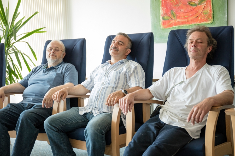 Drei Männer sitzen entspannt beisammen