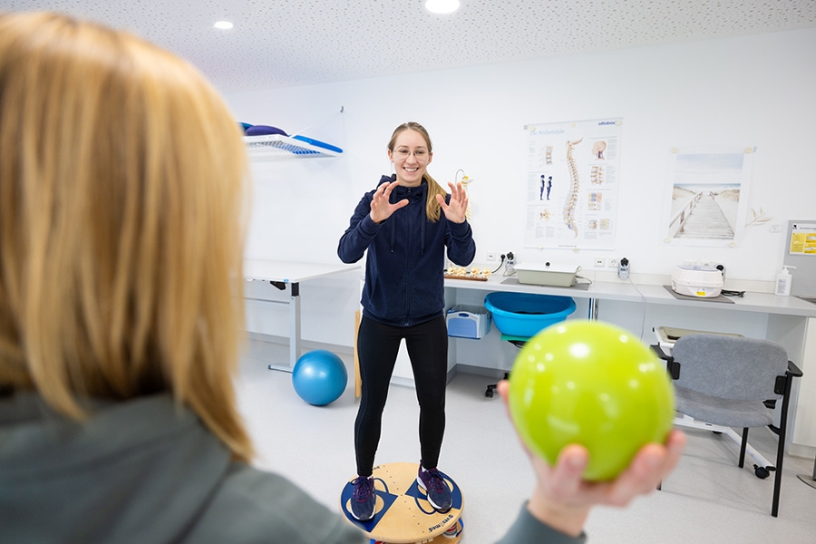 Zwei Personen führen Übung mit einem Ball durch Zwei Personen führen Übung mit einem Ball durch